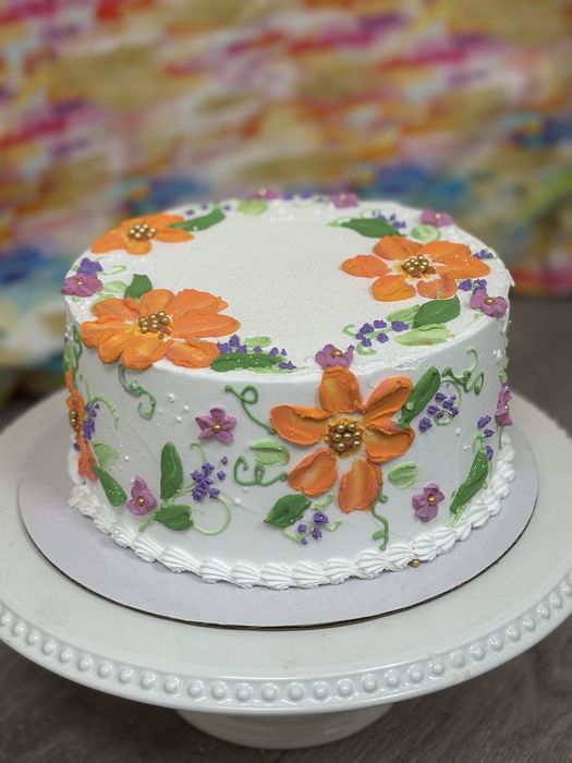 White cake with palette-knife orange buttercream flowers