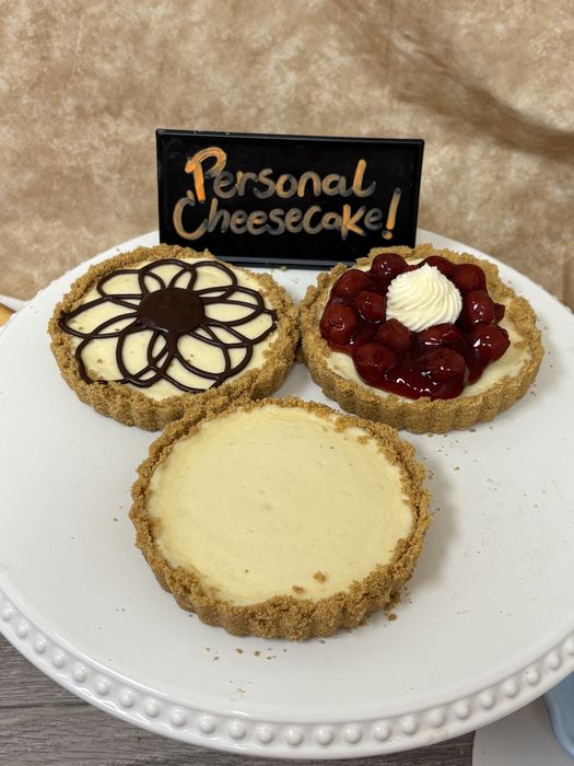 Three personal cheesecakes: cherry, chocolate flower, and classic